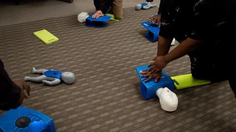 CPR training class by security guard in office Stock Photos