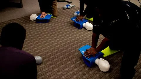 CPR training class by security guard in office Stock Photos