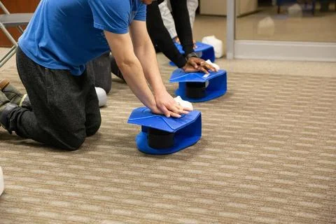 CPR training class by security guard in office Stock Photos