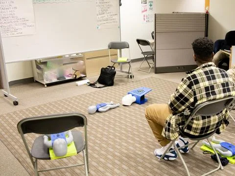CPR training class by security guard in office Stock Photos