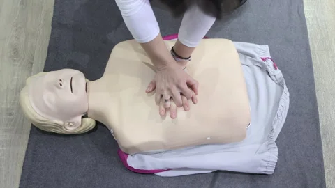 CPR training on a medical dummy with hands positioned correctly for chest Stock Footage 307545396