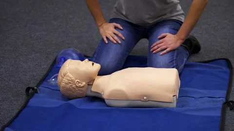 CPR training medical procedure. Demonstrating chest compressions on CPR doll Stock Footage 144009702
