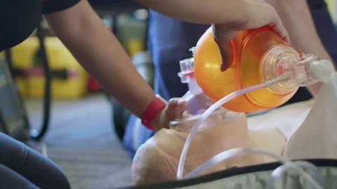 CPR Training Student Demonstrates Bag-Valve-Mask Ventilation on Medical Manikin Stock Footage 337690796