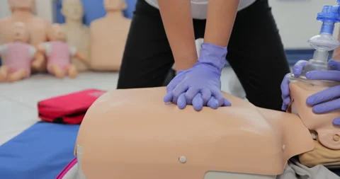 CPR training using and an AED and bag mask valve on an adult training manikin. Stock Footage 163971955