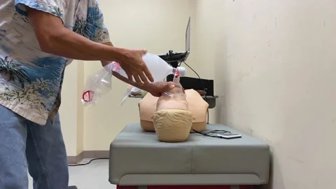 CPR ventilation rescue breaths training practice ambu bag mannequin dummy, audio Stock Footage 156407209