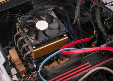 CPU fan with dust inside of a PC computer case with poor cable management Stock Photos