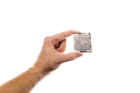 CPU with old thermal paste on IHS in man's hand isolated on white background. Stock-Fotos