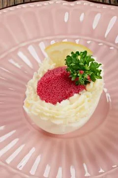 Crab-stuffed deviled egg with parsley garnish Stock Photos
