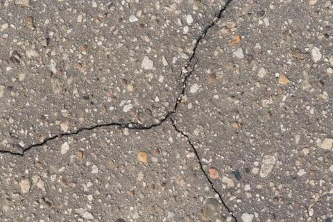 A crack in the asphalt divides the surface into three parts. Stock Photos