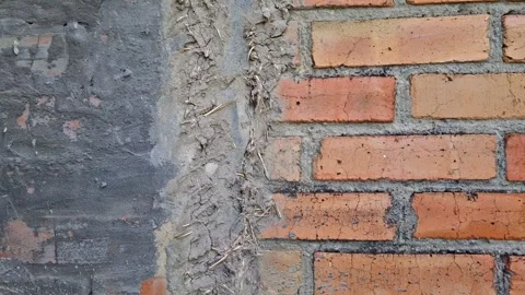 Crack in the brick wall of the house, covered by hand with a mixture of clay and Stock Footage 340930515