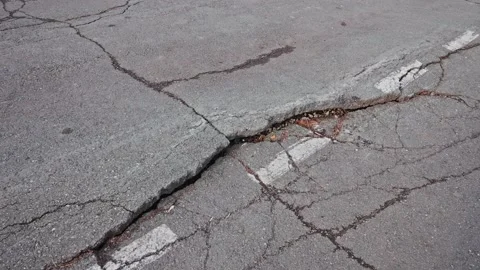 Crack with deep faults on the road next to the white road markings Stock Footage 209162305