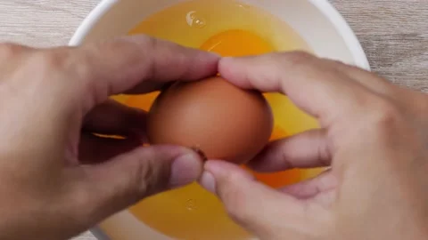 Crack eggs into a bowl Stockbeeldmateriaal 232942582