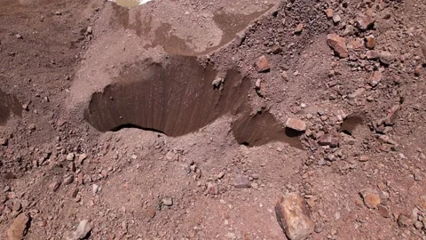 A crack on a glacier covered with rocks. Video stock 158875970