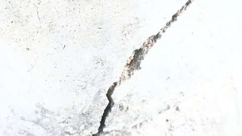 A crack has appeared in the cement wall. Stockbeeldmateriaal 330542708