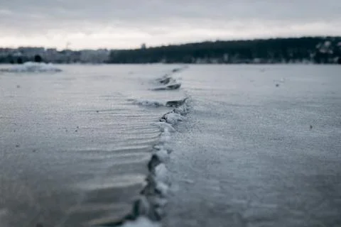 Crack in the ice a cloudy sunset / winter landscape cloudy gloomy Stock Photos