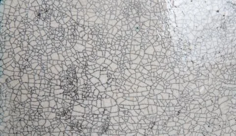 A crack pattern in the glaze of a ceramic plate. Stock Photos
