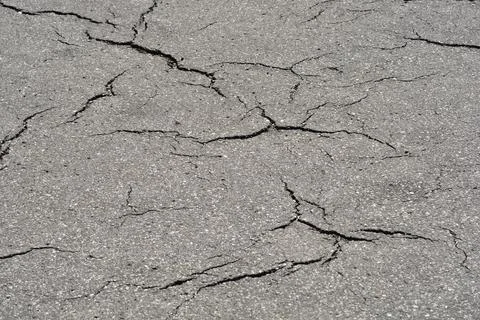 Cracked asphalt road texture in a horizontal full frame background Stock Photos