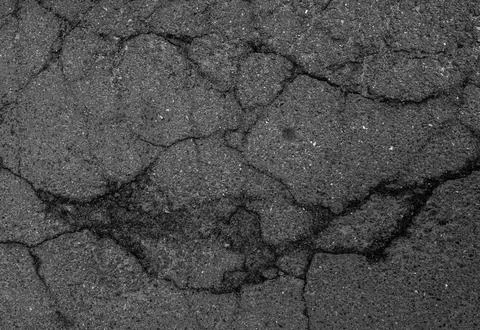 Cracked asphalt surface texture close-up, damaged road pavement background,.. 库存照片