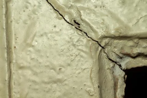 A cracked beige wall texture background with rough surface and damage Fotos Stock