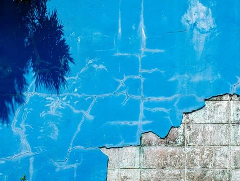 Cracked Blue Wall Texture with Tree Shadow and Exposed Concrete Corner Stock-Fotos