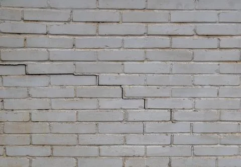 Cracked Brick Wall with Visible Damage 스톡 사진