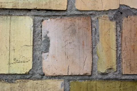 Cracked cement wall of large multi-colored brick Stock Photos