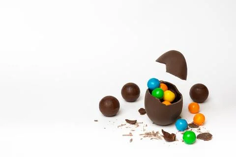Cracked chocolate easter egg with colorful small round candies and chocolates Stock Illustration
