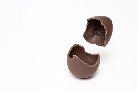 Cracked chocolate Easter egg on a light background, copy space. A broken milk Stock Photos