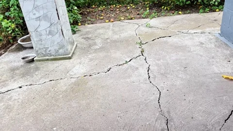 Cracked Concrete Courtyard Surface with Natural Weathering and Drainage Vídeos de archivo 344055632