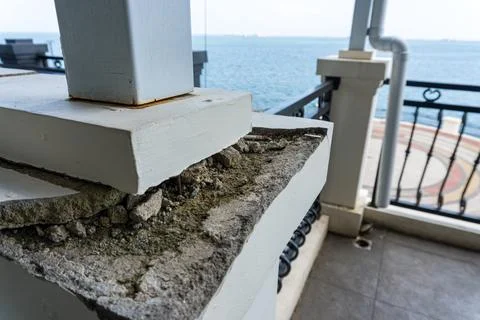 Cracked Concrete Support Column Base on Building Balcony 스톡 사진