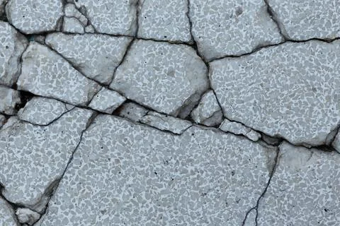 The cracked concrete surface indicates severe structural damage. Stock Photos