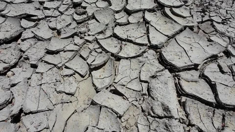 Cracked dry ground exposing deep fractures, signaling severe drought conditions 库存影片 308157444