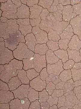Cracked dry soil texture in reddish brown earth, drought pattern background.. Stockfoto's