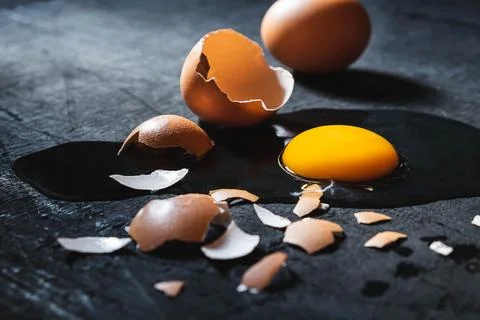 A cracked egg with an egg shell, egg yolk and egg white on white background Foto stock