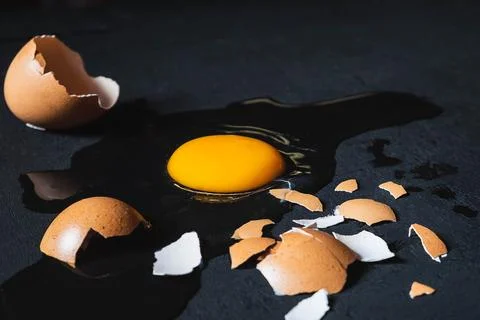 A cracked egg with an egg shell, egg yolk and egg white on white background Foto stock