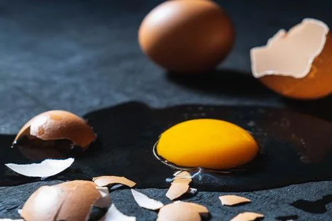 A cracked egg with an egg shell, egg yolk and egg white on white background Foto stock