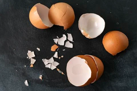 Cracked egg shell isolated on dark background, ingredients for cooking Stock Photos