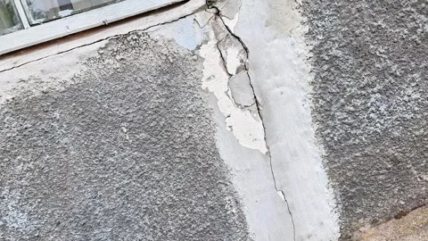 Cracked Exterior Wall Plaster Beneath Window Showing Structural Wear Stock-Footage 336596037