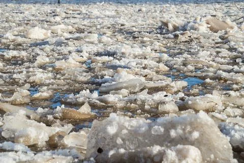 Cracked ice floating springtime on blue water mountain lake Stock Photos