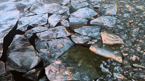 Cracked ice floats on surface of frozen river during sunset Stock-Footage 332132002