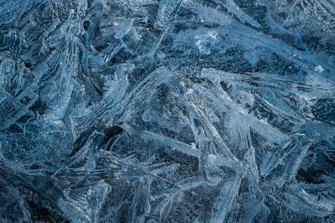 Cracked ice formations with intricate patterns cover a frozen surface Stock Photos