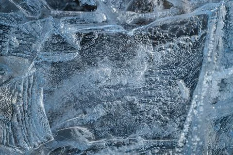 Cracked ice formations with intricate patterns cover a frozen surface Stock Photos