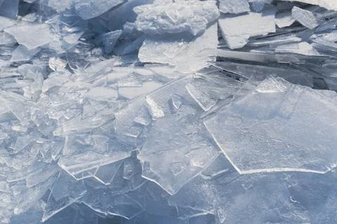 Cracked ice forms a textured surface on a frozen lake during winter in a co.. Stock Photos
