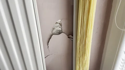 Cracked Interior Wall with Damaged Plaster Near Window Stock Footage 345513652