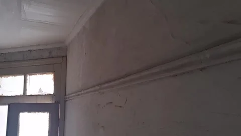 Cracked interior wall motion footage showing textured plaster room decay Stock Footage 345362127