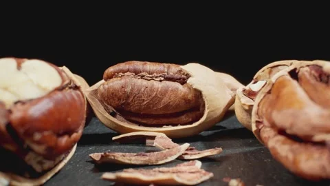 Cracked pecans at black background. Dolly slider. Group of unpeeled pecan Stock Footage 291441311