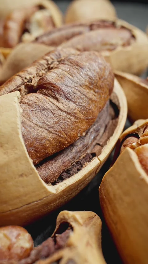 Cracked pecans rotating. Group of unpeeled pecans. Delicious nuts. Vegan food. Stock Footage 289510106