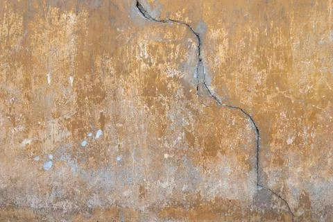 Cracked plaster facade with exposed old paint layers Stock Photos