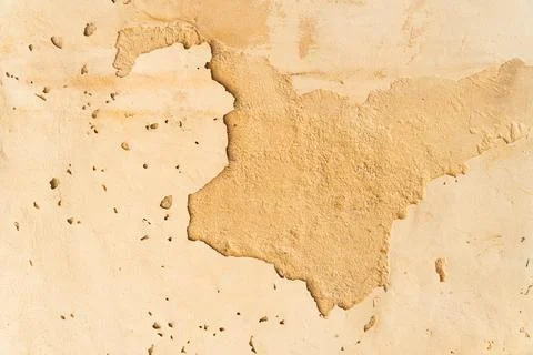 Cracked plaster wall texture with peeling surface revealing layered stone Stock Photos