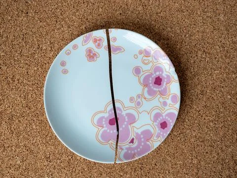 Cracked plate on the background of a cork table Stock Photos